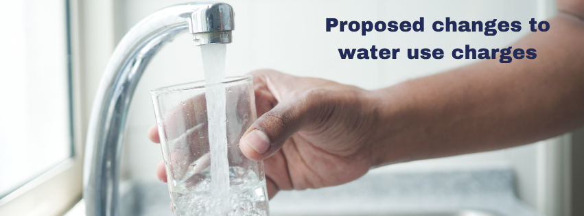 Photo of a hand holding a glass filling with water from a tap with heading words Changes to Water Use charges 